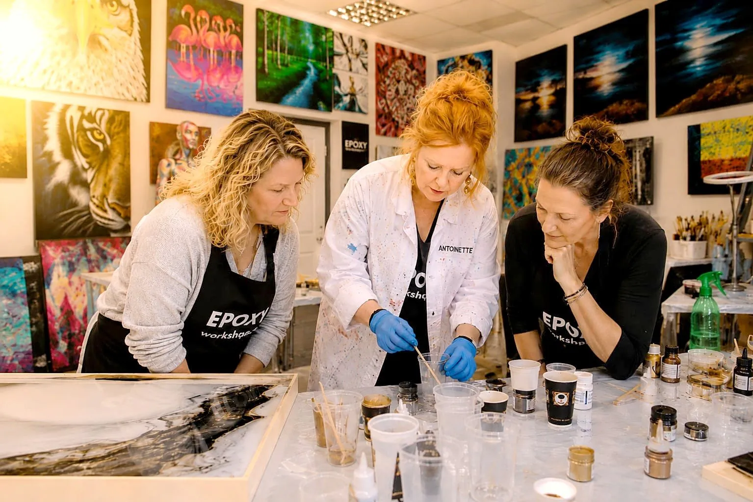 Antoynette explains pigment mixing to two participants at the workbench