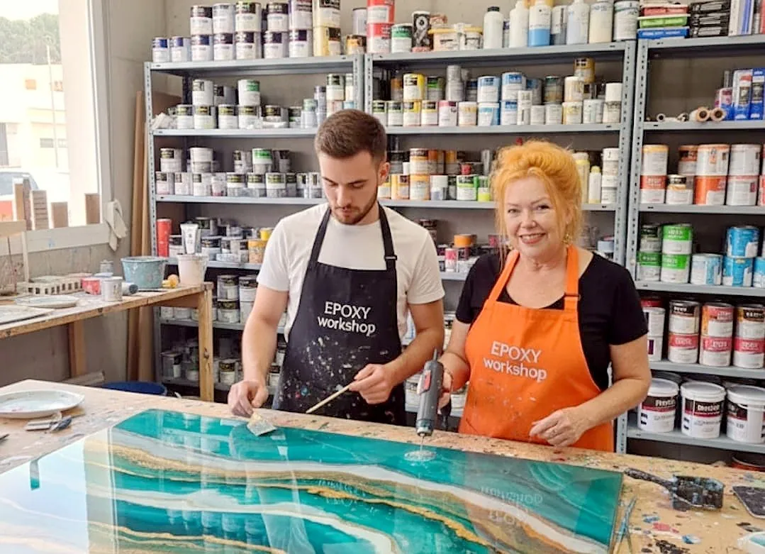 Antoynette coaching a participant one-to-one on a large turquoise epoxy panel